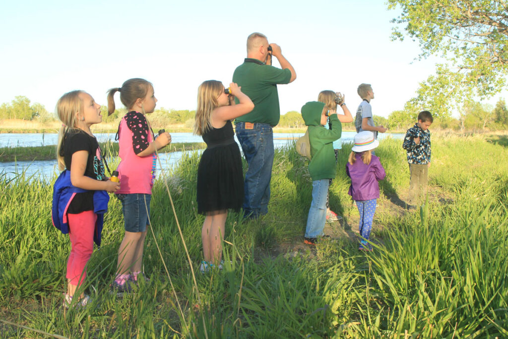 Lincoln County. TJ Walker (green shirt) leads kids on a birding hike along the North Platte River at Buffalo Bill Ranch SRA as part of a birding day hosted by NGPC. Julie Geiser, May 12, 2016. Copyright Nebraskaland Magazine/Nebraska Game and Parks Commission.